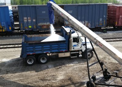 unloading overloaded rail car into truck